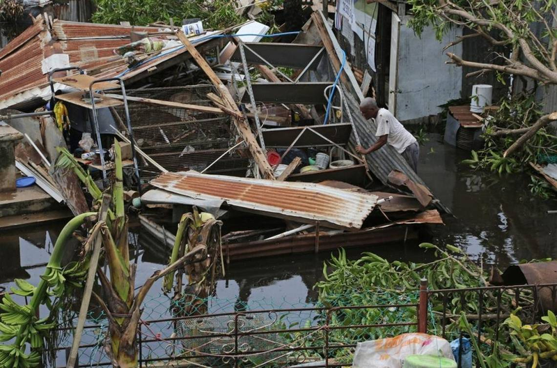 Farmer Victor Lozada searches Friday for items that can be salvage from his shed in Puerto Rico that was completely destroyed by Hurricane Maria. (Carl Juste/Miami Herald)